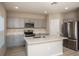 Modern kitchen features stainless steel appliances, gray cabinets, and a center island at 37009 Sagemoor Dr, Zephyrhills, FL 33541