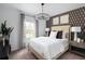 Inviting bedroom with patterned wallpaper, warm lighting, and a cozy bed, creating a serene and comfortable space at 37029 Sagemoor Dr, Zephyrhills, FL 33541