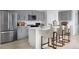 A bright kitchen features stainless steel appliances, a center island with chairs, and ample cabinet space at 37029 Sagemoor Dr, Zephyrhills, FL 33541