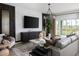 Spacious living room featuring a large TV, modern furniture, and a bright, airy atmosphere with outdoor views at 37029 Sagemoor Dr, Zephyrhills, FL 33541