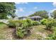 Lush landscaped backyard featuring vibrant garden beds and a screened-in pool area at 4418 Gentrice Dr, Valrico, FL 33596