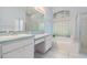 Bright bathroom featuring a double vanity, soaking tub, and separate glass-enclosed shower at 4418 Gentrice Dr, Valrico, FL 33596