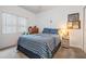 Comfortable bedroom with a blue and white striped bedspread, featuring neutral walls and soft carpeting at 4418 Gentrice Dr, Valrico, FL 33596