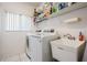 Bright laundry room featuring a washer, dryer, utility sink, and shelving for storage at 4418 Gentrice Dr, Valrico, FL 33596