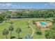 Beautiful aerial view of the pool and playground area with nearby walking paths and palm trees at 4506 La Capri Ct, Tampa, FL 33611
