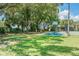 Well-maintained community basketball court with green turf, large trees, and a walking path at 4506 La Capri Ct, Tampa, FL 33611