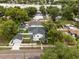 An aerial view of a two-story white house with new roof and garage in a neighborhood with mature trees at 502 E Robles St, Tampa, FL 33602