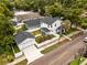 Aerial view showcasing a home with a white picket fence, garage, and lush landscaping at 502 E Robles St, Tampa, FL 33602