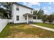 Spacious backyard featuring a cozy covered patio, lush green lawn, and charming white fence at 502 E Robles St, Tampa, FL 33602