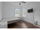 A cozy bedroom has wood-look floors and bright natural light through two windows at 502 E Robles St, Tampa, FL 33602