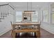 Dining space with a wooden table, bench seating, and an elegant light fixture, near staircase and living room at 502 E Robles St, Tampa, FL 33602