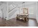 Dining area with a wooden table, bench seating, and an elegant chandelier, adjacent to the staircase at 502 E Robles St, Tampa, FL 33602