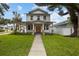 Charming two-story home showcasing a meticulously landscaped yard and inviting covered porch with stylish columns at 502 E Robles St, Tampa, FL 33602