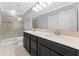 Bathroom with large mirror, double vanity, walk-in glass shower and neutral tile at 5153 Bay Isle Cir, Clearwater, FL 33760