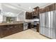 Kitchen with granite countertops, stainless steel appliances, and dark brown cabinetry at 5153 Bay Isle Cir, Clearwater, FL 33760