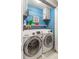 Efficient laundry room with modern washer and dryer units, storage cabinets, and bright blue walls at 5153 Bay Isle Cir, Clearwater, FL 33760