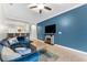 Cozy living room features a decorative fireplace, mounted TV, and comfortable blue sofa at 5153 Bay Isle Cir, Clearwater, FL 33760