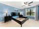 Bright main bedroom with a ceiling fan, large window, and blue accent wall at 5153 Bay Isle Cir, Clearwater, FL 33760