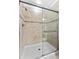 Close up of the glass shower with neutral tile and black tiled accent at 5153 Bay Isle Cir, Clearwater, FL 33760