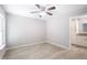 Light-filled bedroom with tile flooring, ceiling fan, and an adjacent kitchen view at 5319 Lantana St, Zephyrhills, FL 33542