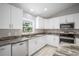 Stylish kitchen featuring granite countertops, stainless steel appliances, and white cabinetry at 5319 Lantana St, Zephyrhills, FL 33542