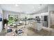 Open kitchen featuring stainless steel appliances, white cabinetry, a central island, and an adjacent dining area at 5319 Lantana St, Zephyrhills, FL 33542
