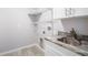 Laundry area with a utility sink, cabinet, and built-in shelving at 5319 Lantana St, Zephyrhills, FL 33542