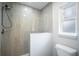 Updated shower with grey tiles, a shower head, white base, and window at 5319 Lantana St, Zephyrhills, FL 33542