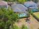 Aerial view of the property highlighting a swimming pool, screened-in patio, lush landscaping, and backyard playset at 5813 Bent Grass Dr, Valrico, FL 33596