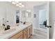 Bathroom with dual sinks, wood cabinets, large mirror, and shower/tub combination at 5813 Bent Grass Dr, Valrico, FL 33596