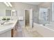 Bathroom featuring double sinks, tile floor and a glass enclosed shower and tub at 5813 Bent Grass Dr, Valrico, FL 33596