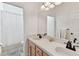 Bathroom with dual sinks, wood cabinets, large mirror, and shower/tub combination at 5813 Bent Grass Dr, Valrico, FL 33596
