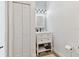 Charming half-bathroom with beadboard accent wall, modern vanity, and storage shelves, blending style and functionality at 5813 Bent Grass Dr, Valrico, FL 33596