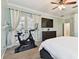 A bright primary bedroom featuring a ceiling fan and a view of an exercise bike and wall mounted television at 5813 Bent Grass Dr, Valrico, FL 33596