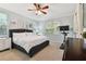 Bright bedroom with a ceiling fan, white walls, carpeted floors and a large window bringing in natural light at 5813 Bent Grass Dr, Valrico, FL 33596