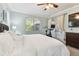 Light-filled bedroom features white bedding, a ceiling fan, and natural light from large windows and access to an outdoor patio at 5813 Bent Grass Dr, Valrico, FL 33596