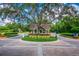 Well-maintained community entrance with brick-paved road, lush landscaping, and a charming guard house at 5813 Bent Grass Dr, Valrico, FL 33596