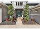 Front entrance of a gray home with a brick walkway, a pair of double front doors, and manicured landscaping at 5813 Bent Grass Dr, Valrico, FL 33596