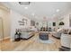 A living room with an open floor plan, wood floors, a grey sofa, and a decorative wall arrangement at 5813 Bent Grass Dr, Valrico, FL 33596