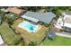 Aerial view of a home with a pool, shed and a fenced yard at 5871 Oakhurst Dr, Seminole, FL 33772