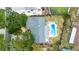 Aerial view of a home with a private pool and lush landscaping, set on a well-maintained lot with mature trees at 5871 Oakhurst Dr, Seminole, FL 33772