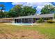 View of the home's backyard, highlighting the pool and covered patio at 5871 Oakhurst Dr, Seminole, FL 33772