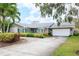 Charming single-story home with a well-manicured front yard and a circular driveway leading to the two-car garage at 5871 Oakhurst Dr, Seminole, FL 33772