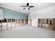 Open-concept living room with exposed wall framing and connections, ceiling fan, and white flooring at 5871 Oakhurst Dr, Seminole, FL 33772