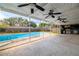 Covered patio with ceiling fans and an outdoor kitchen area overlooking the pool at 5871 Oakhurst Dr, Seminole, FL 33772