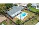 Aerial view of a backyard oasis featuring a refreshing pool, screened enclosure, and well-maintained lawn at 5871 Oakhurst Dr, Seminole, FL 33772
