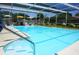 Inviting screened-in pool area with multiple seating areas, lush landscaping, and serene surroundings at 5871 Oakhurst Dr, Seminole, FL 33772