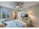 Inviting bedroom features coastal-themed decor, a shuttered window, ceiling fan, and a walk-in closet for ample storage at 6031 Grand Sonata Ave, Lutz, FL 33558
