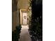 A front door with a decorative wreath, framed by foliage and accented by outdoor lighting at 6031 Grand Sonata Ave, Lutz, FL 33558