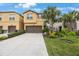 Charming tan two-story townhome with well-manicured landscaping and a large driveway at 6031 Grand Sonata Ave, Lutz, FL 33558